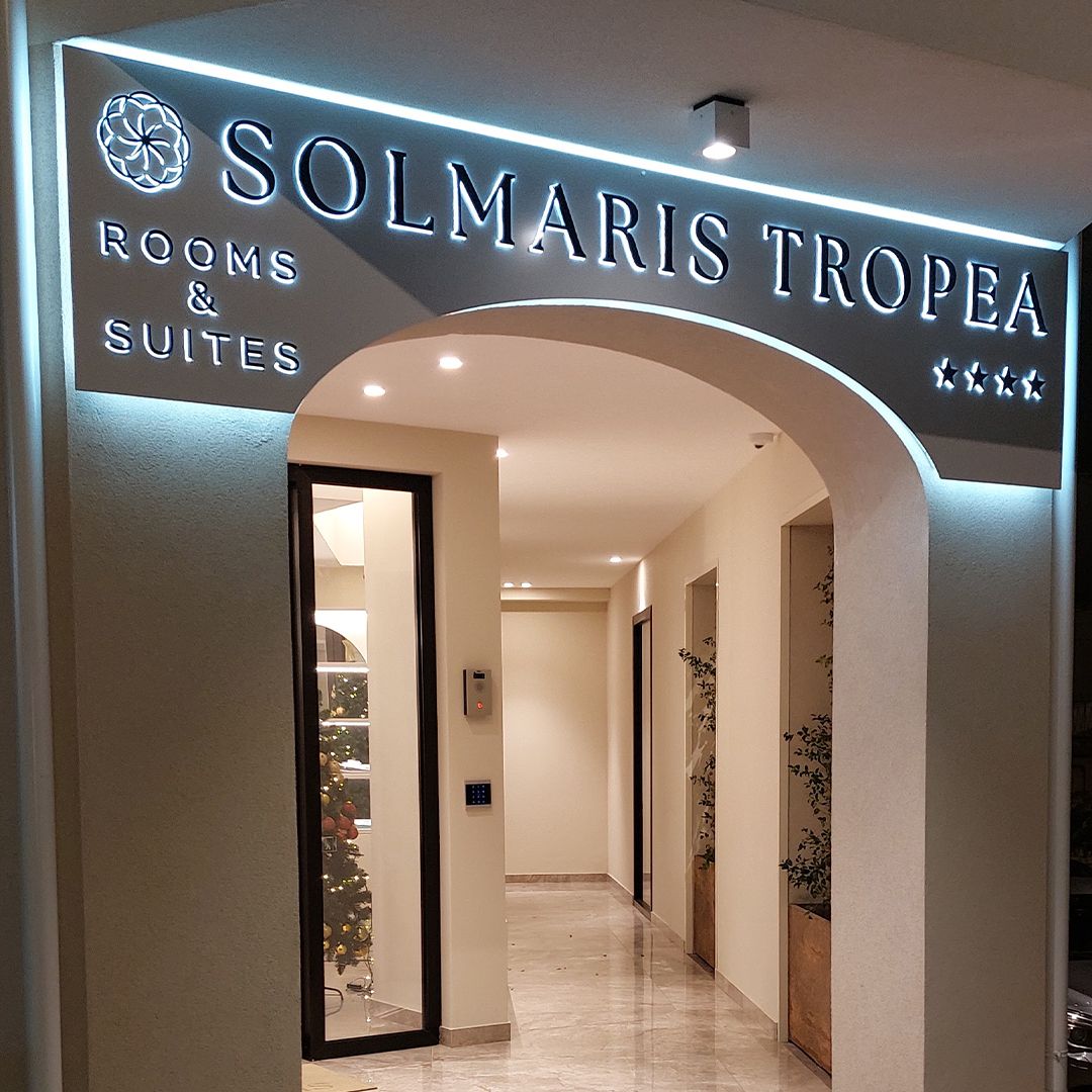 SOLMARIS TROPEA Insegna retroilluminata in dibond bianco con doppie lettere a rilievo in plexiglass trasparente e nero lucido con laterali luminosi